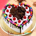 send half kg black forest gems heart shape cake delivery